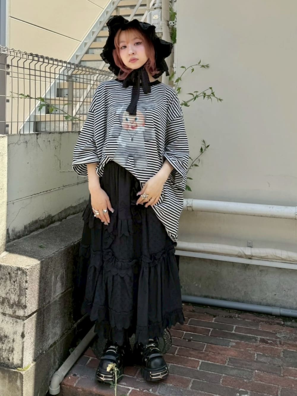 ブラック系のTシャツ/カットソー、ブラック系のスカート、ブラック系のハットを着用したレディースの夏コーディネートの2枚目の写真