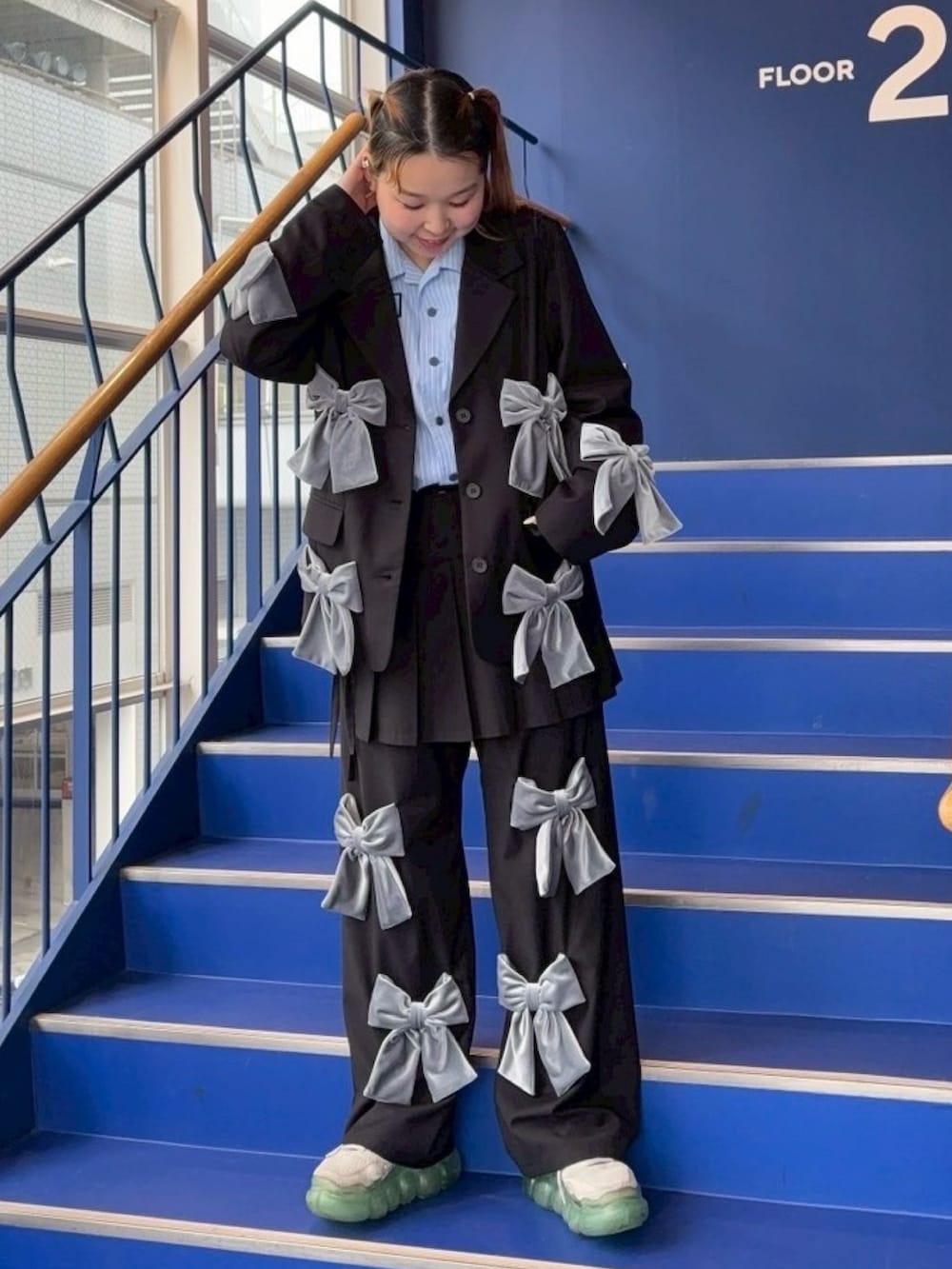 ブラック系のテーラードジャケット、ブルー系のシャツ/ブラウス、ブラック系のその他パンツを着用したレディースの春コーディネートの2枚目の写真