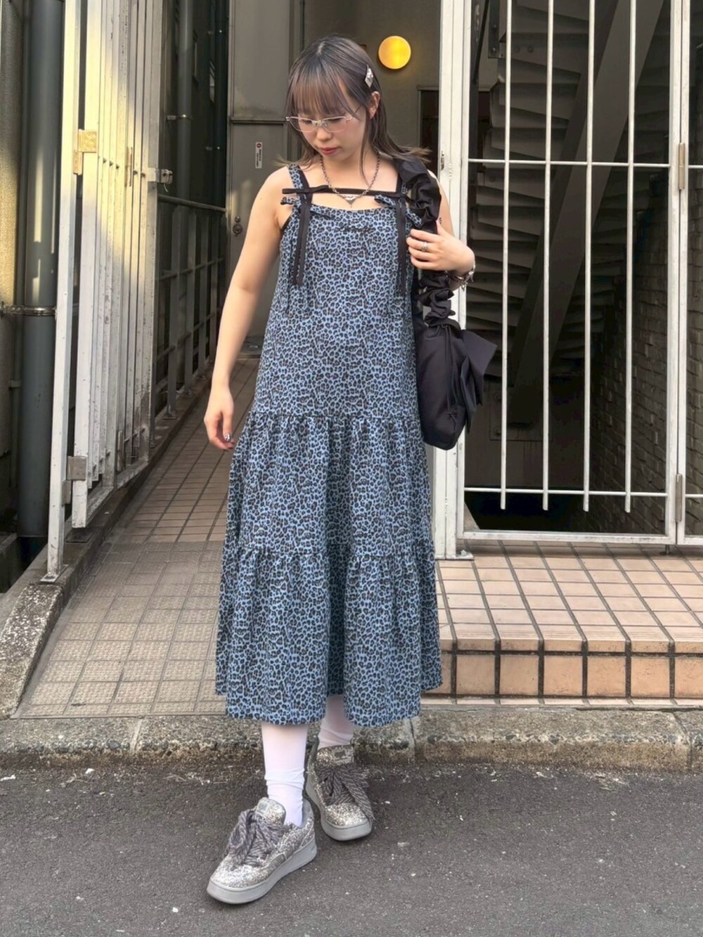 ブラック系のショルダーバッグ、ブラック系のキャミソール、ブルー系のワンピースを着用したレディースの春コーディネートの3枚目の写真