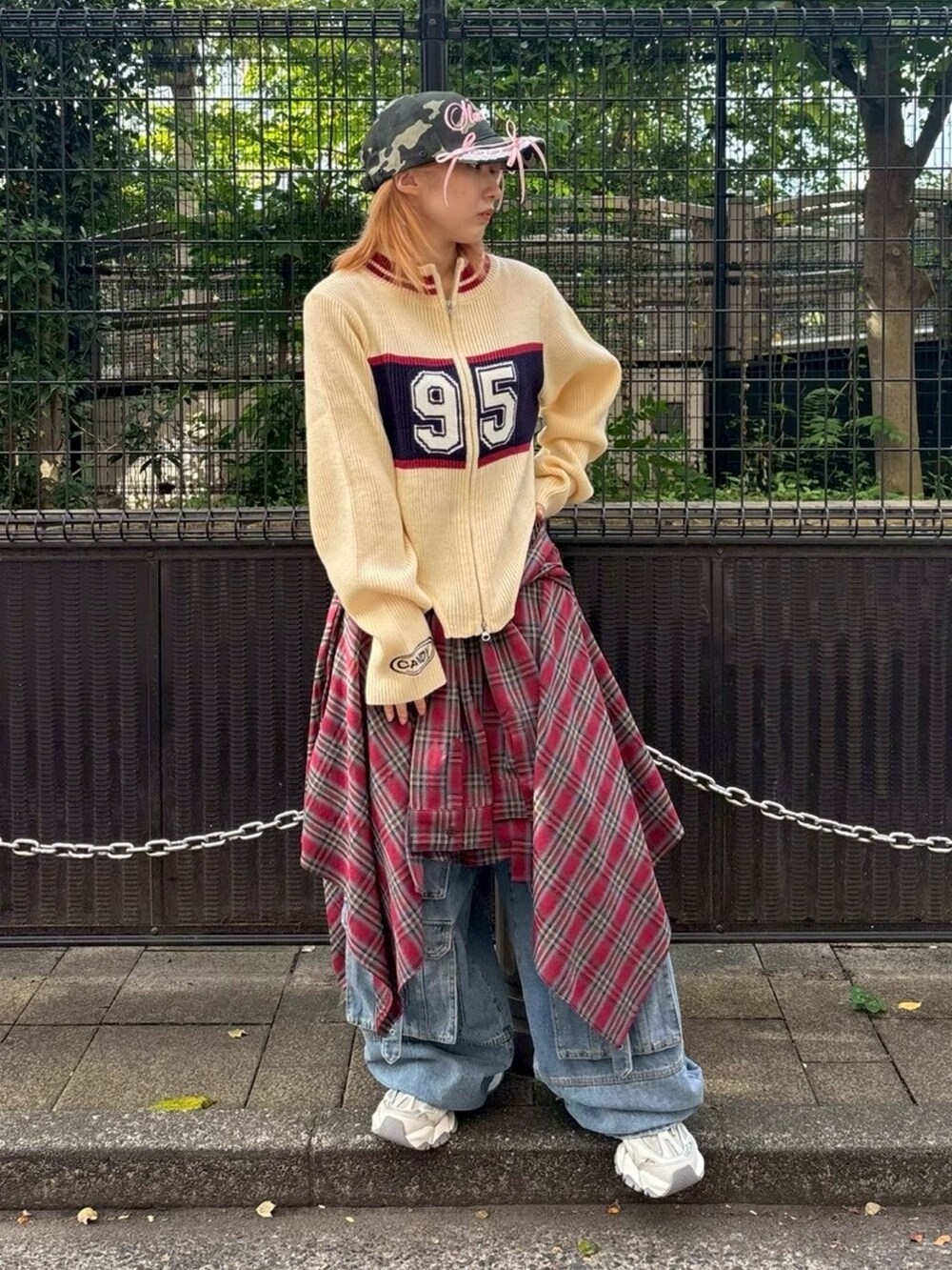 ブルー系のデニムパンツ、レッド系のスカート、ホワイト系のニット/セーターを着用したレディースの秋コーディネートの4枚目の写真