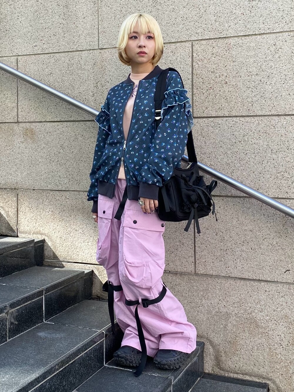 ブラック系のブルゾン、ピンク系のTシャツ/カットソー、ピンク系のカーゴパンツを着用したレディースの春コーディネートの2枚目の写真