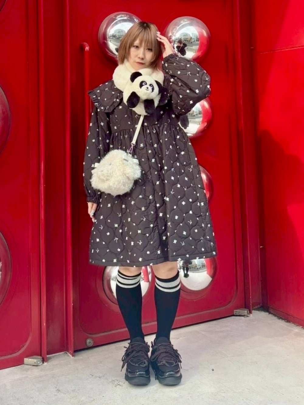 ホワイト系のショルダーバッグ、ブラック系のダウンジャケット/コート、ブラック系のソックス/靴下を着用したレディースの冬コーディネートの2枚目の写真