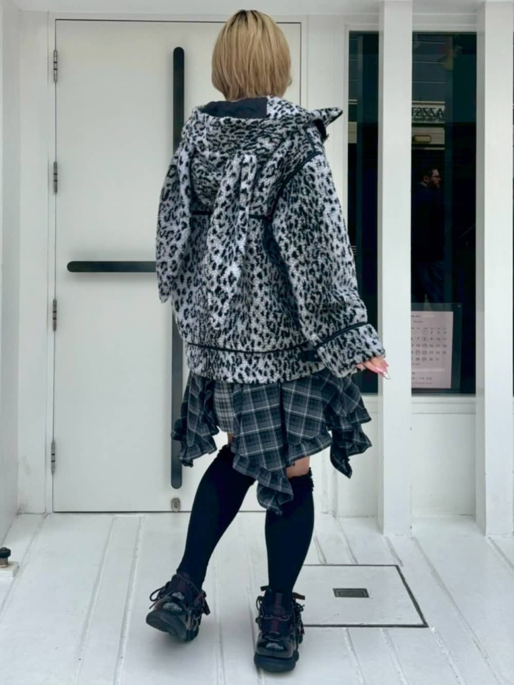 グレー系のダウンジャケット/コート、ブラック系のワンピース、グレー系のニット/セーターを着用したレディースの秋コーディネートの4枚目の写真