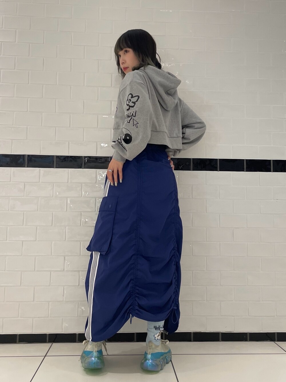 ブルー系のスカート、グレー系のパーカー、ブルー系のソックス/靴下を着用したレディースの冬コーディネートの3枚目の写真