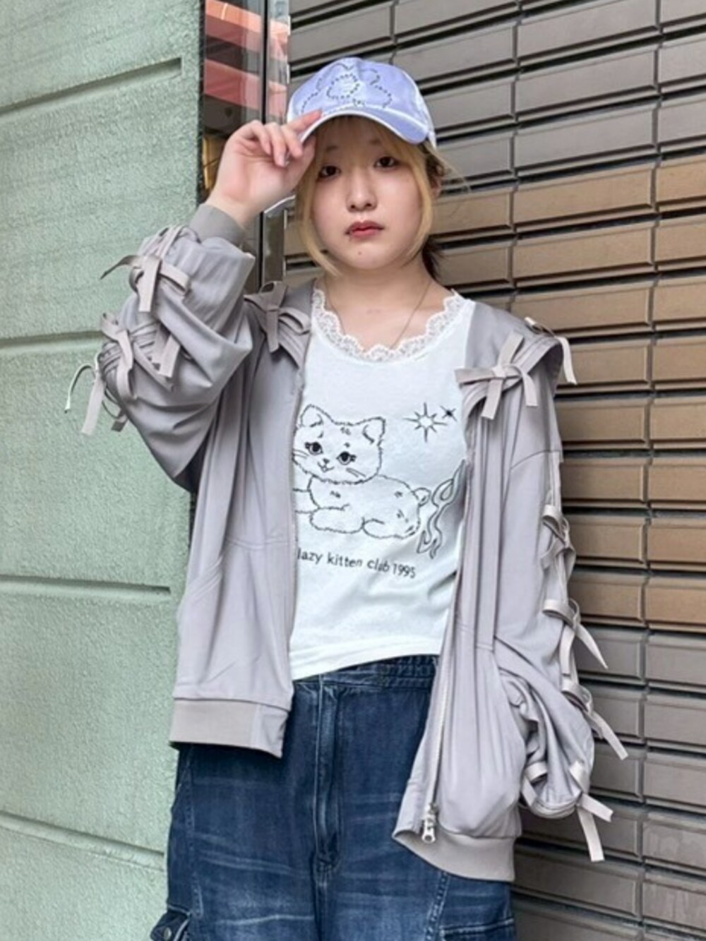 ブルー系のデニムパンツ、ホワイト系のタンクトップ、グレー系のブルゾンを着用したレディースの春コーディネートの4枚目の写真