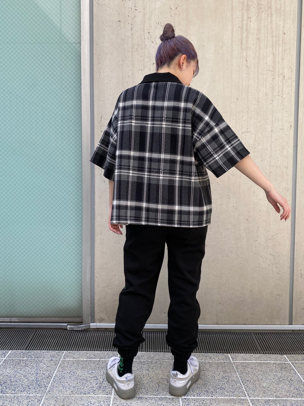 ブラック系のスウェットパンツ、ブラック系のポロシャツを着用したレディースの春コーディネートの3枚目の写真