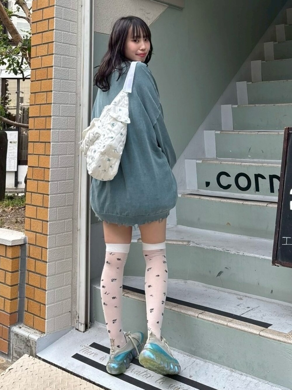 ホワイト系のTシャツ/カットソー、ブルー系のカーディガン/ボレロ、ホワイト系のスカートを着用したレディースの秋コーディネートの6枚目の写真