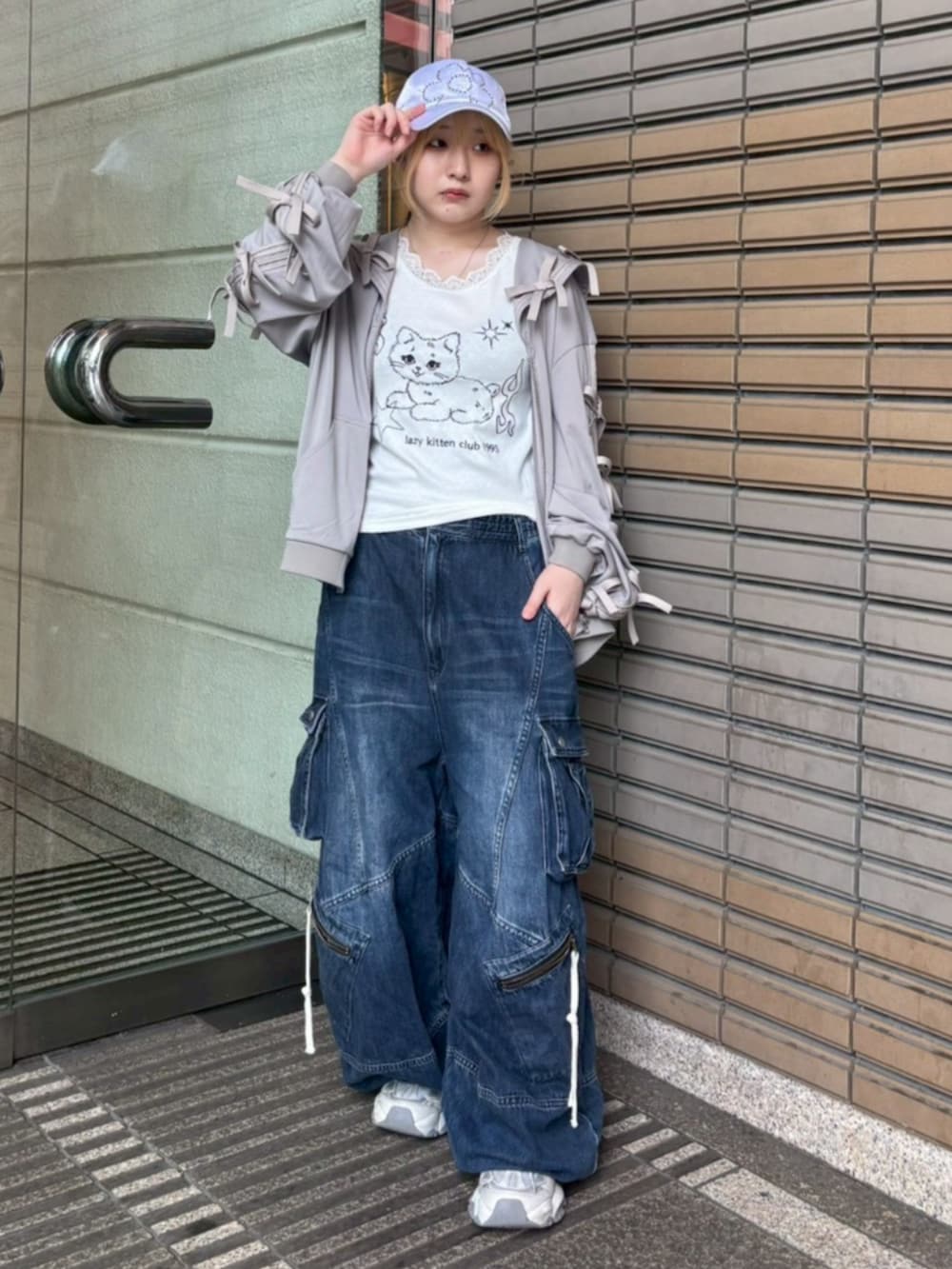 ブルー系のデニムパンツ、ホワイト系のタンクトップ、グレー系のブルゾンを着用したレディースの春コーディネートの2枚目の写真