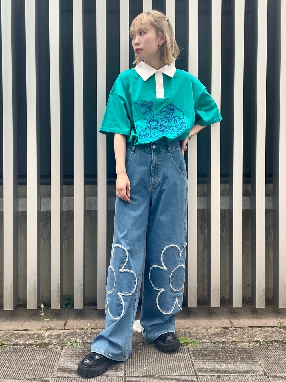 ブラック系のローファー、ブルー系のデニムパンツ、グリーン系のポロシャツを着用したレディースの夏コーディネートの3枚目の写真