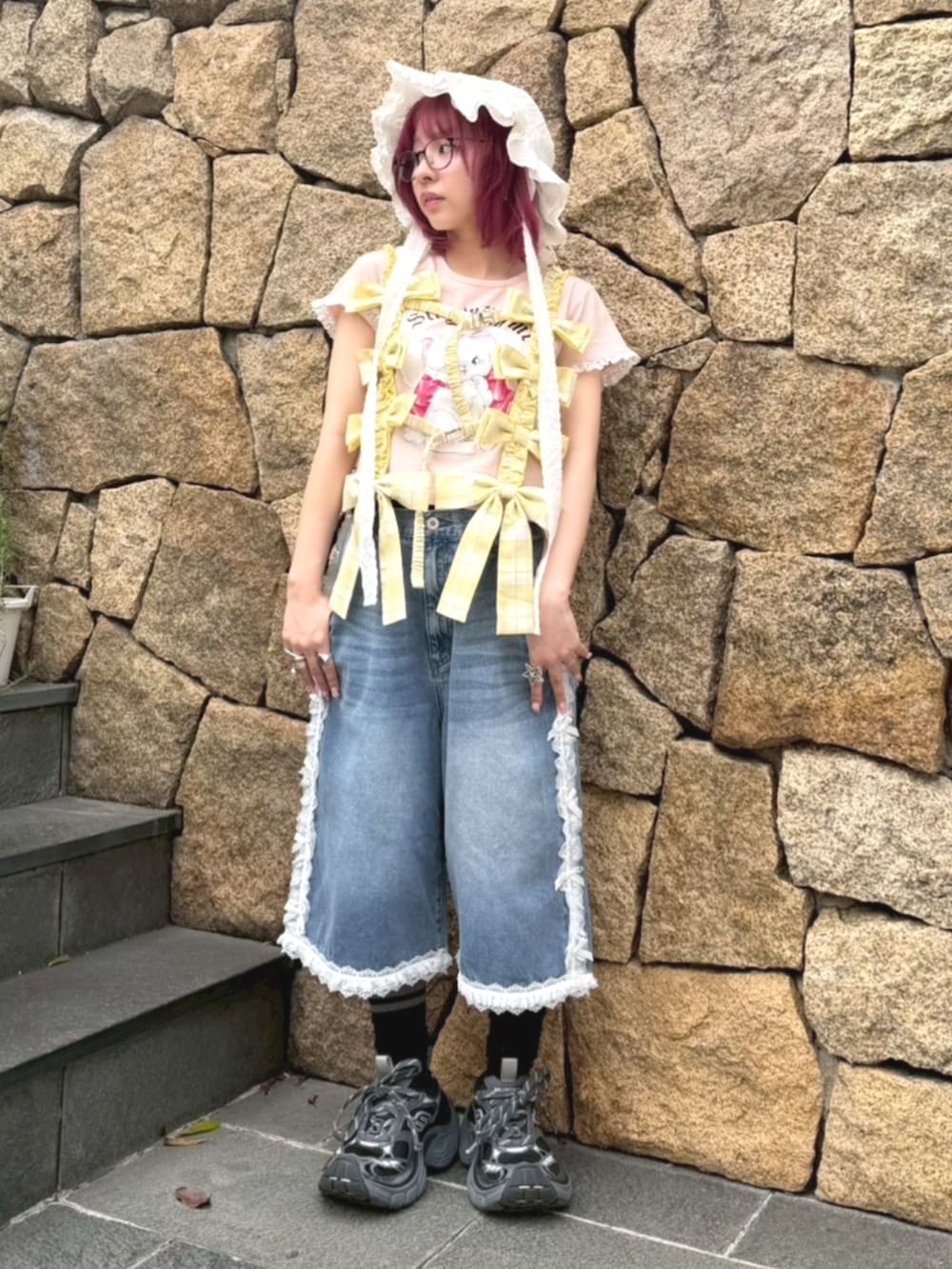 ピンク系のTシャツ/カットソー、イエロー系のその他トップス、ブルー系のデニムパンツを着用したレディースの春コーディネートの2枚目の写真