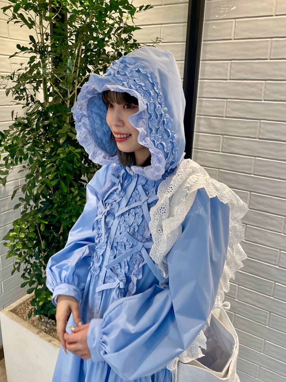 ブルー系のワンピース、ホワイト系のショルダーバッグ、ホワイト系のブーツを着用したレディースの冬コーディネートの5枚目の写真