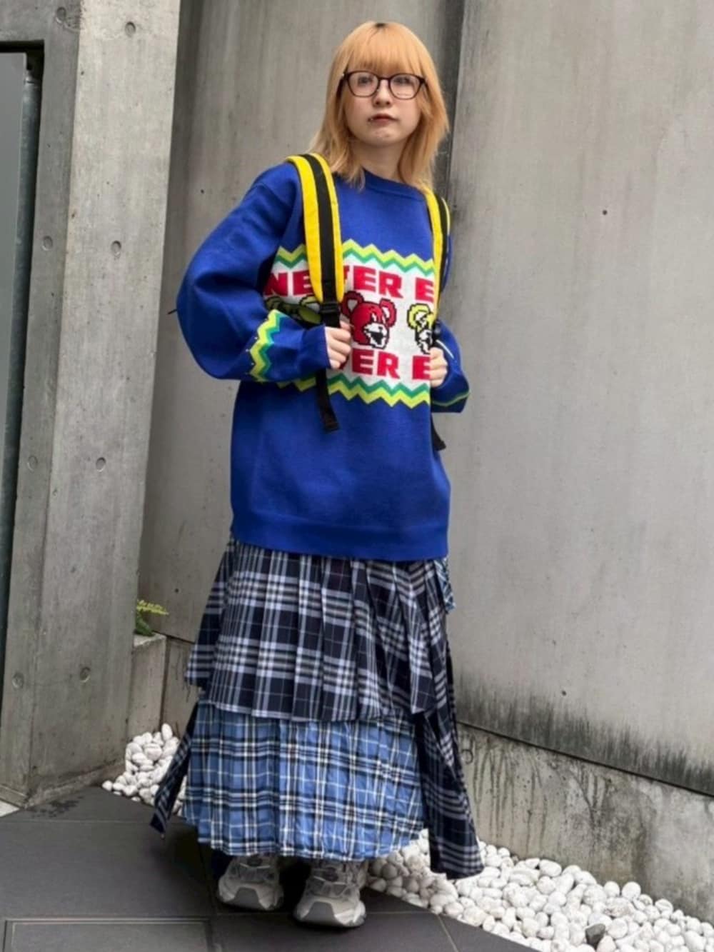 レッド系のバックパック/リュック、ブルー系のスカート、ブルー系のニット/セーターを着用したレディースの秋コーディネートの4枚目の写真