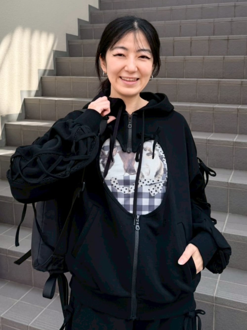 ブラック系のボディバッグ/ウエストポーチ、ブラック系のパーカー、ブラック系のTシャツ/カットソーを着用したレディースの春コーディネートの4枚目の写真