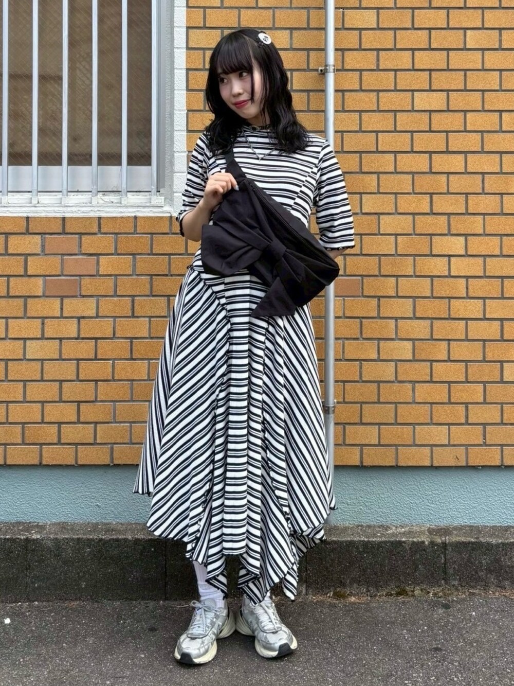 ブラック系のワンピース、ブラック系のボディバッグ/ウエストポーチ、ホワイト系のバレッタ/ヘアクリップを着用したレディースの夏コーディネートの2枚目の写真