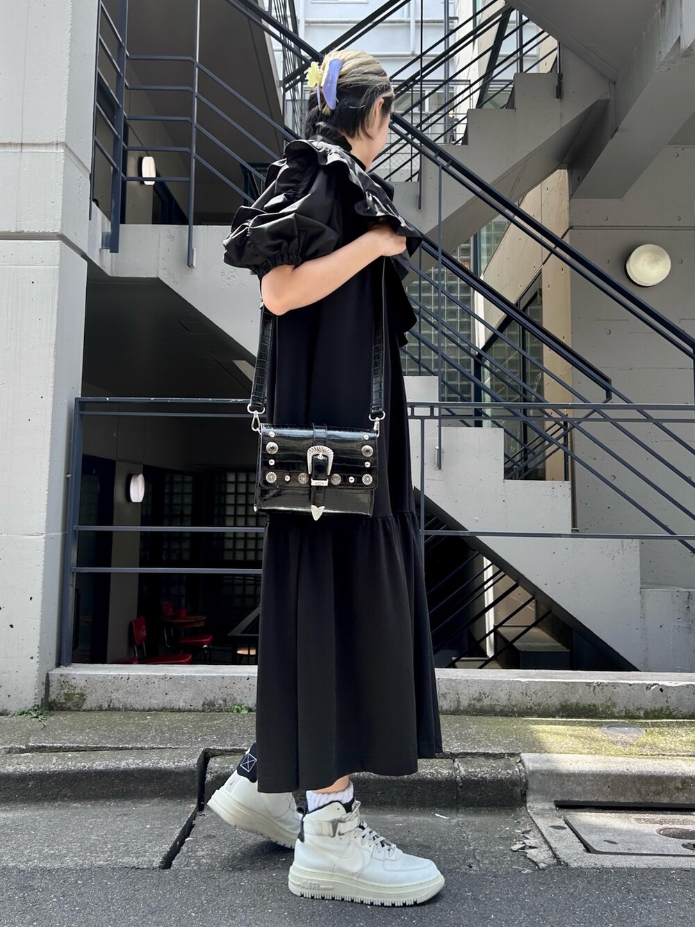 ブラック系のワンピース、ブラック系のショルダーバッグ、ホワイト系のシューズを着用したレディースの夏コーディネートの3枚目の写真