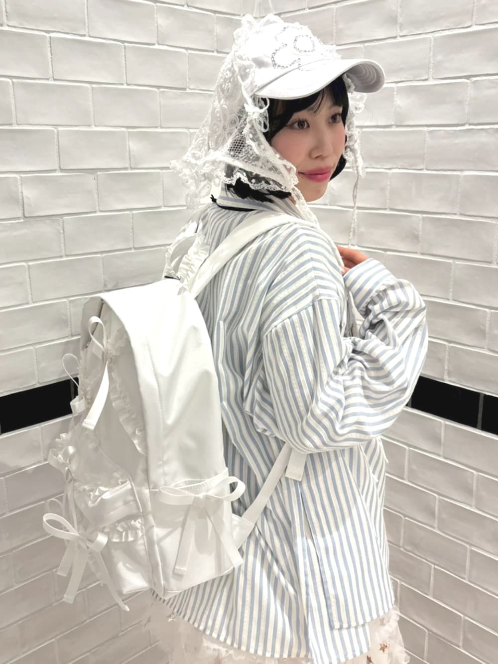 ブルー系のシャツ/ブラウス、ホワイト系のバックパック/リュック、ホワイト系のスカートを着用したレディースの冬コーディネートの5枚目の写真