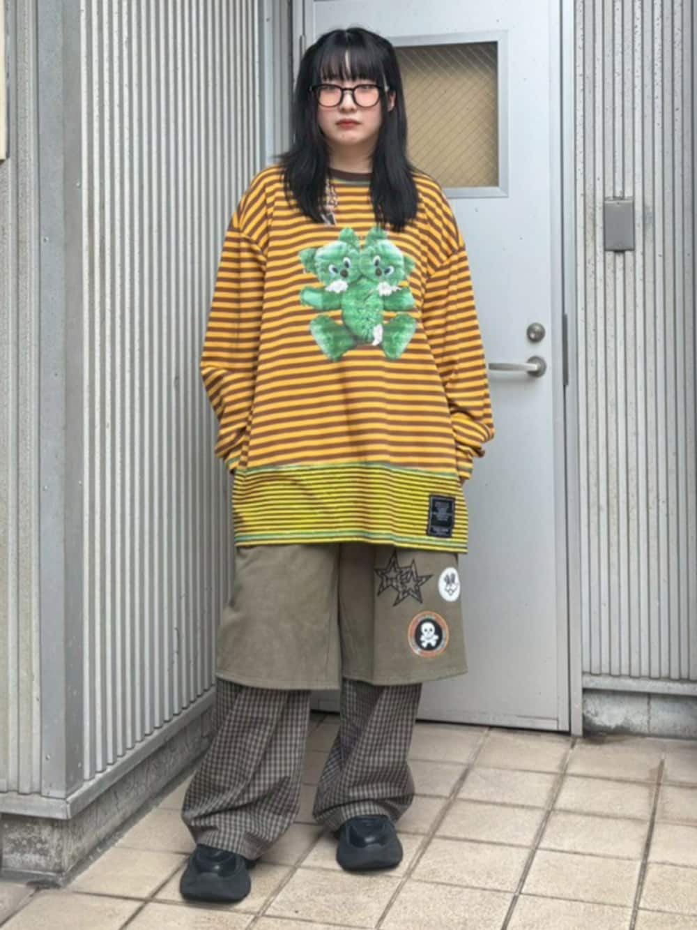 イエロー系のTシャツ/カットソーを着用したレディースの秋コーディネートの2枚目の写真