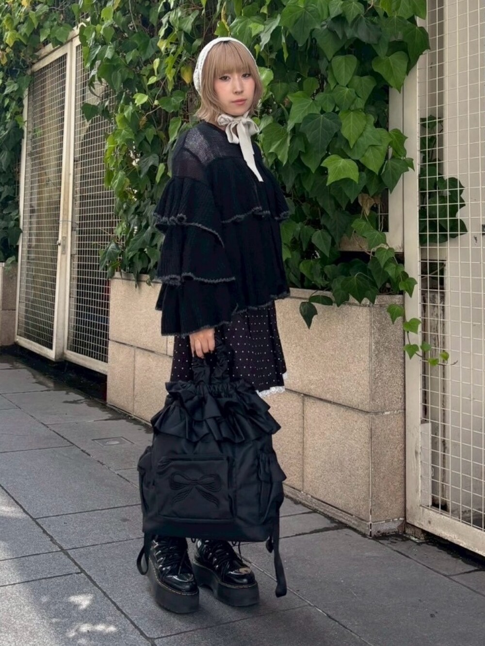 ブラック系のスカート、ブラック系のバックパック/リュック、ブラック系のカーディガン/ボレロを着用したレディースの秋コーディネートの4枚目の写真