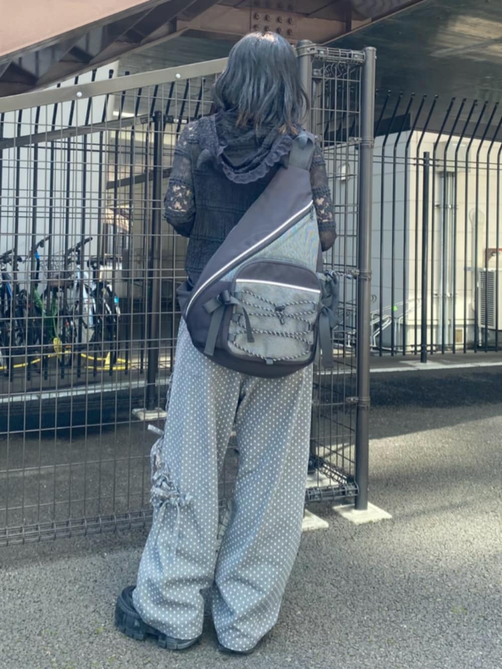 ブラック系のパーカー、ブラック系のショルダーバッグ、ブラック系のデニムパンツを着用したレディースの秋コーディネートの2枚目の写真