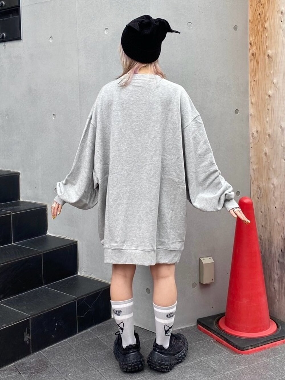 グレー系のスウェット、ブラック系のニットキャップ/ビーニー、グレー系のソックス/靴下を着用したレディースの秋コーディネートの3枚目の写真