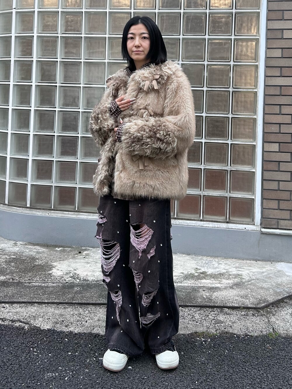 ブラック系のデニムパンツ、ブラウン系のシャツ/ブラウス、ベージュ系のダウンジャケット/コートを着用したレディースの冬コーディネートの4枚目の写真