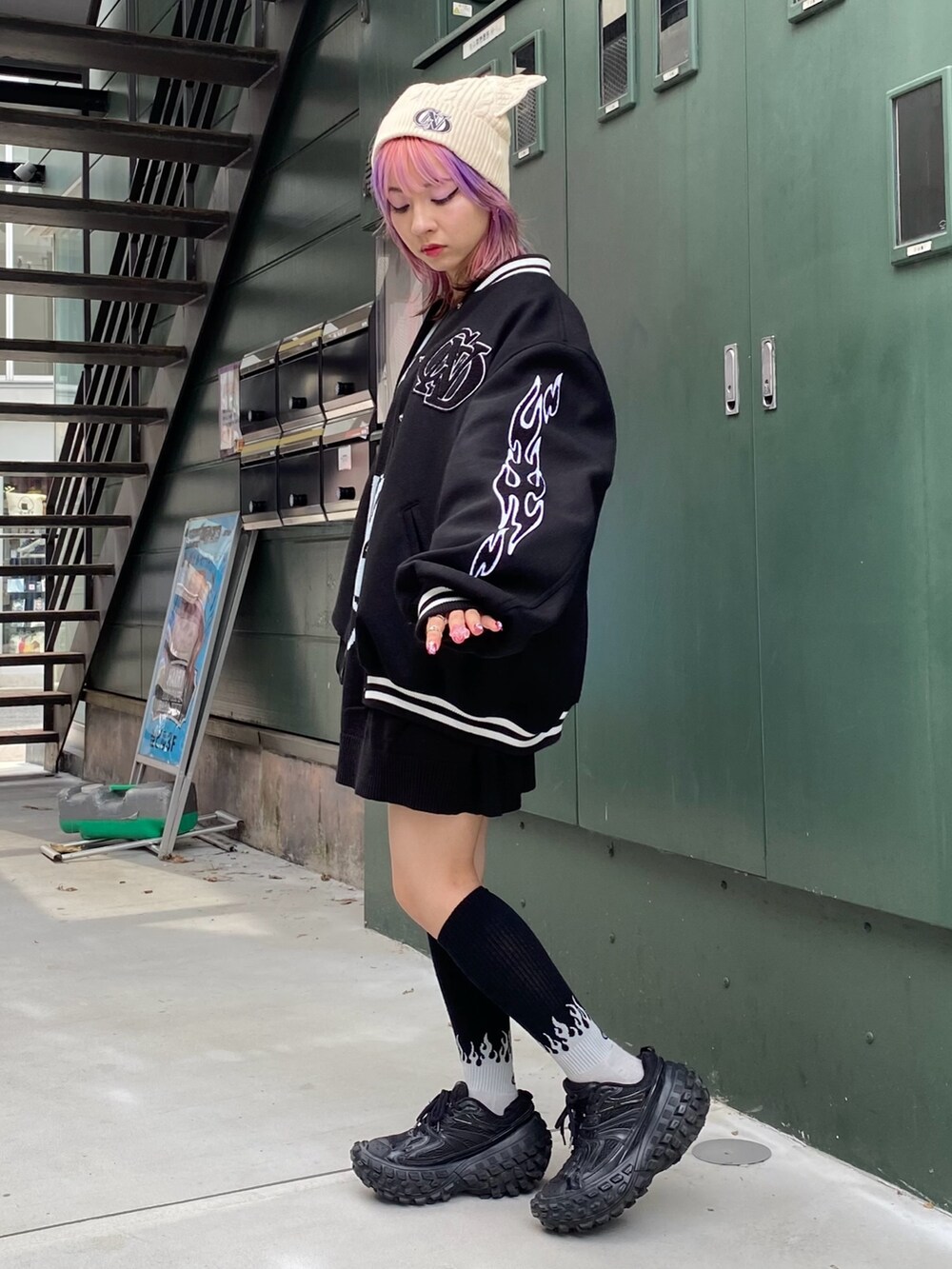 ブラック系のスタジャン、ブラック系のニット/セーター、ホワイト系のニットキャップ/ビーニーを着用したレディースの秋コーディネートの2枚目の写真