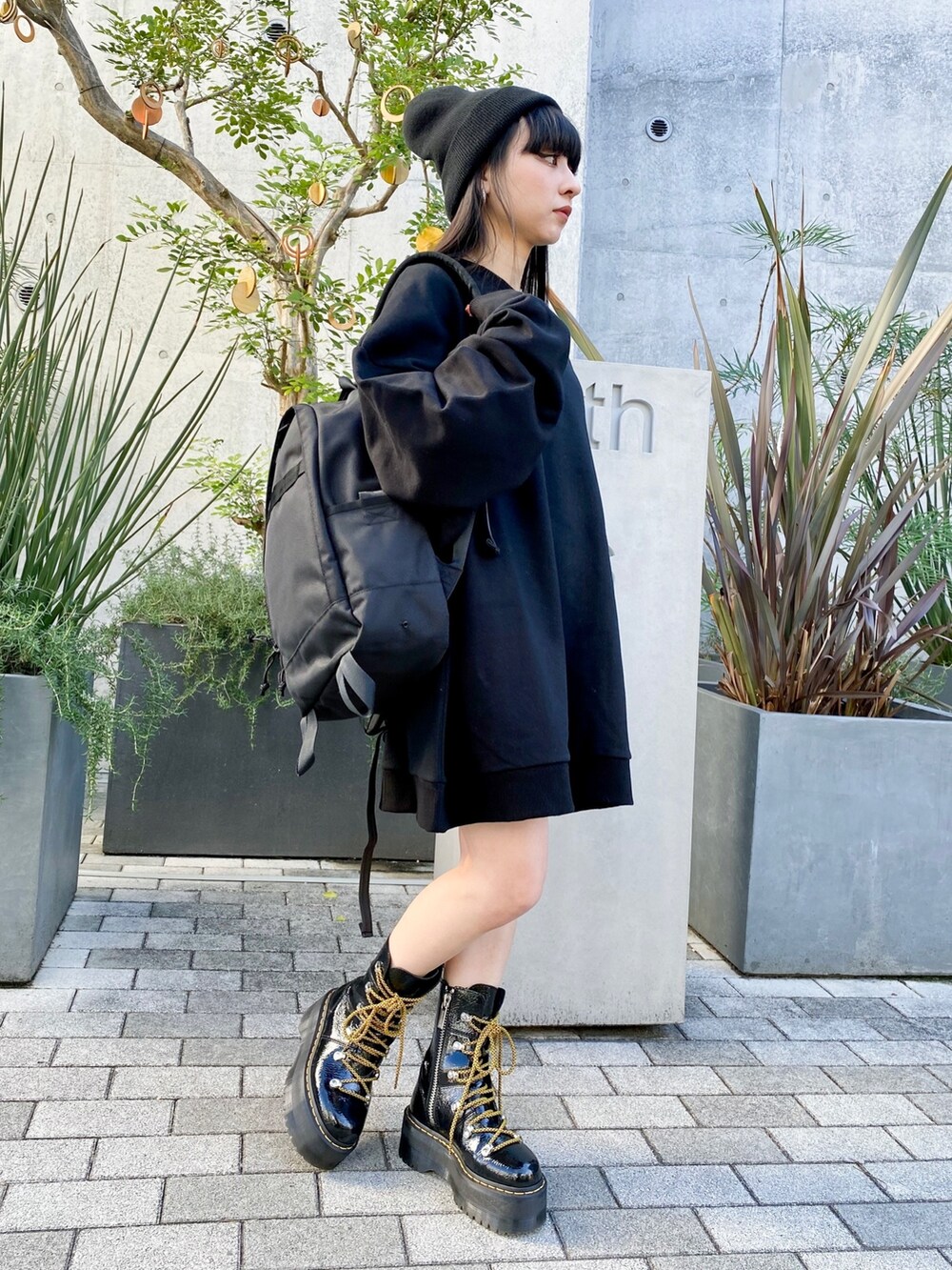 ブラック系のスウェット、ブラック系のバックパック/リュック、ブラック系のシューズを着用したレディースの冬コーディネートの2枚目の写真