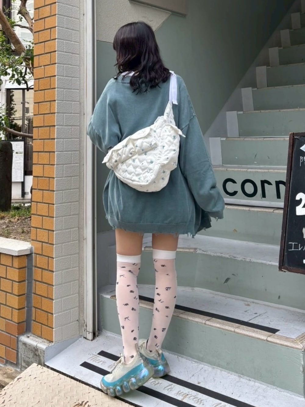 ホワイト系のTシャツ/カットソー、ブルー系のカーディガン/ボレロ、ホワイト系のスカートを着用したレディースの秋コーディネートの5枚目の写真