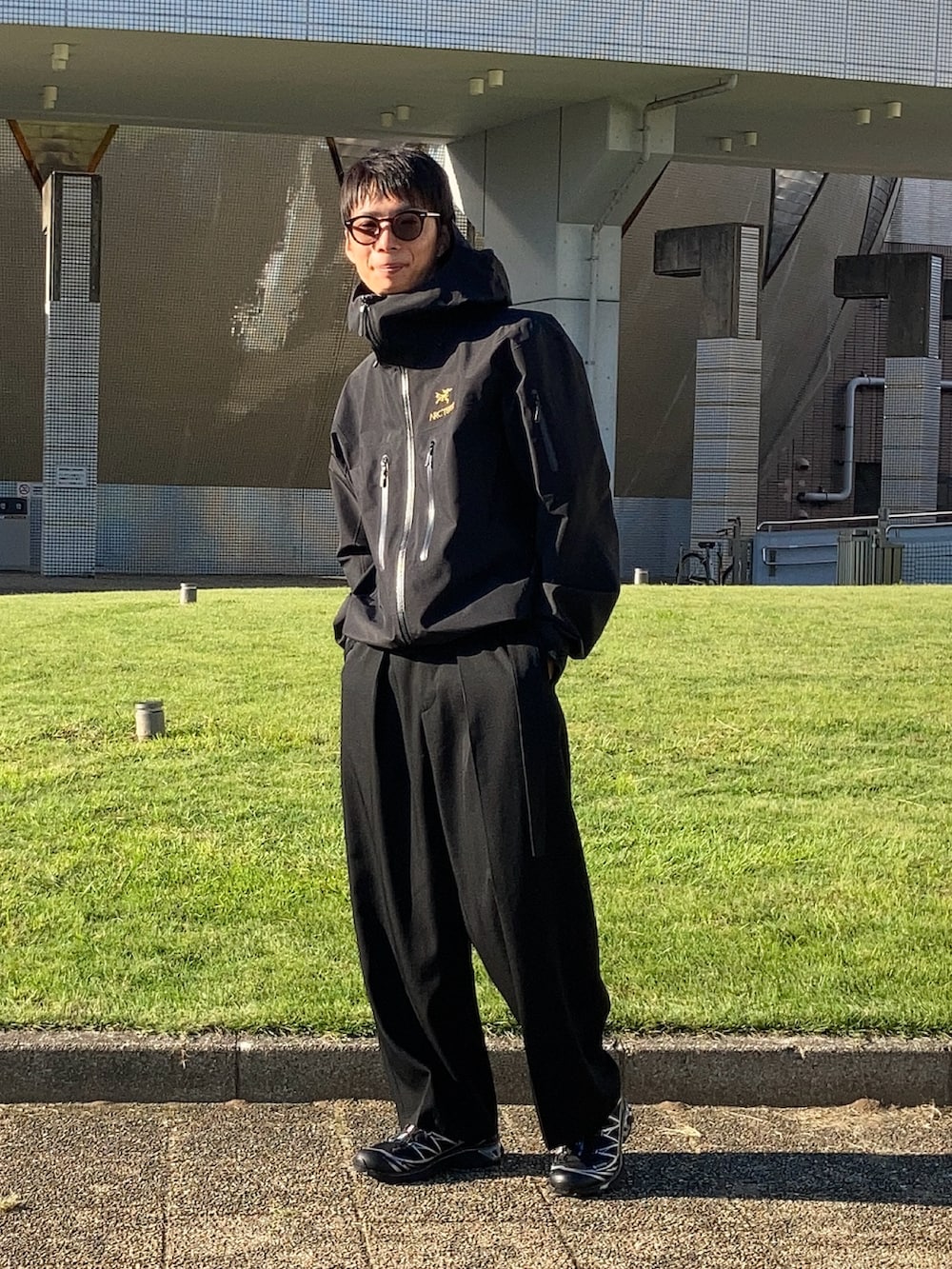 ブラック系のスニーカー、ブラック系のナイロンジャケットを着用したメンズの秋コーディネートの2枚目の写真