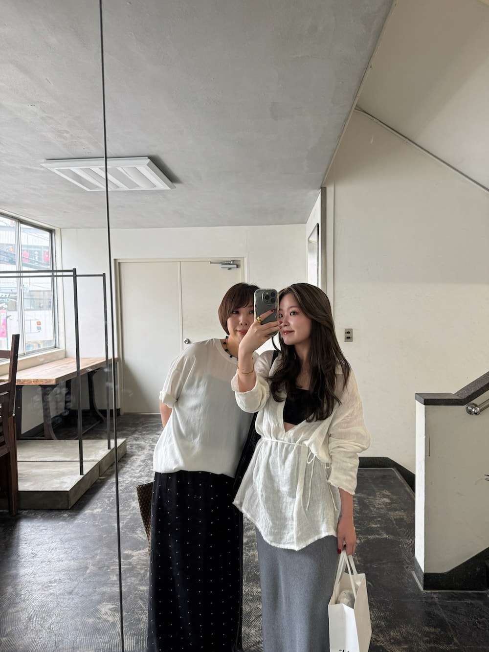 ホワイト系のシャツ/ブラウスを着用したレディースの夏コーディネートの2枚目の写真