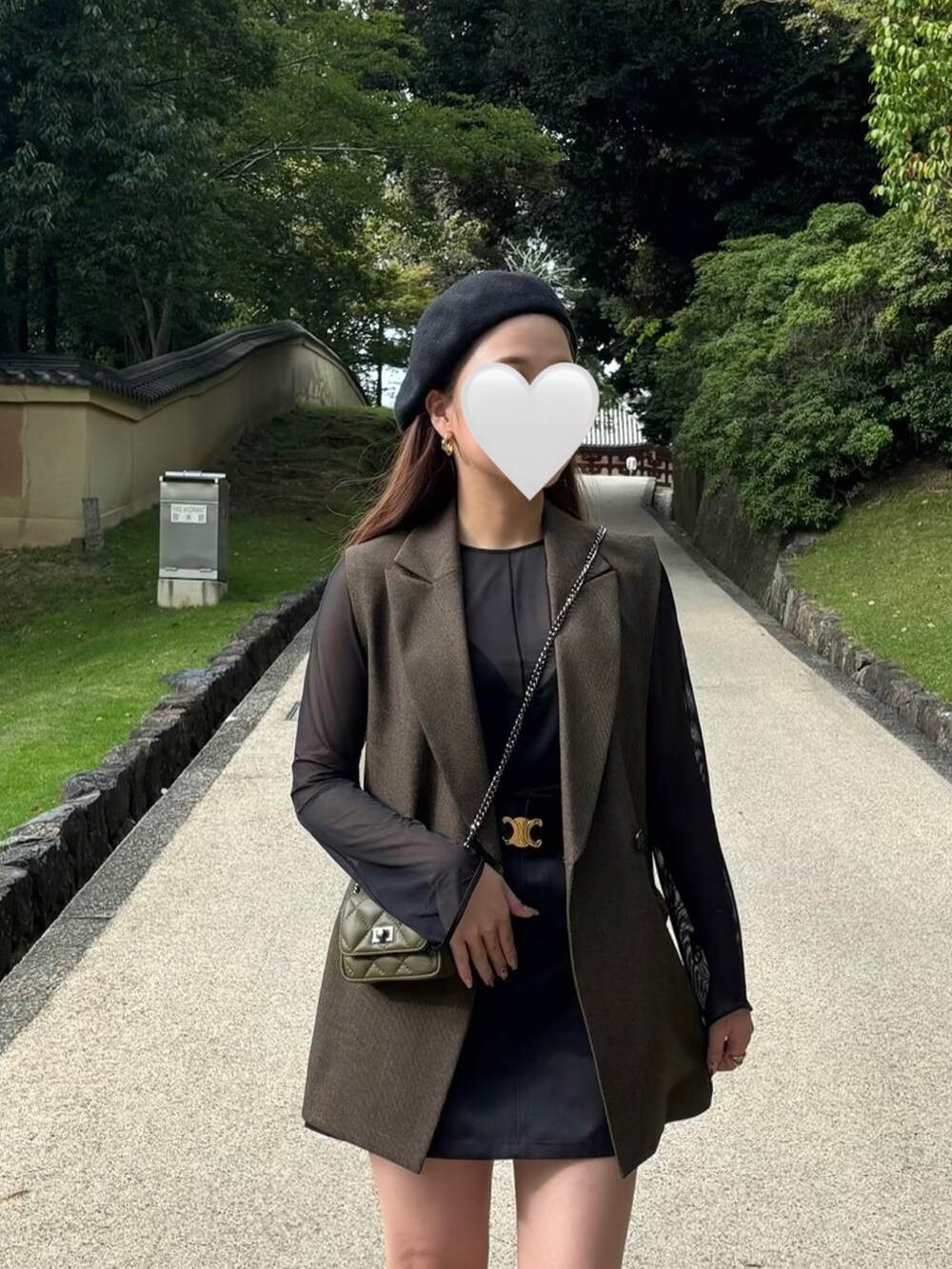 ブラウン系のベスト、ブラック系のトップス、ブラック系のスカートを着用したレディースの秋コーディネートの2枚目の写真