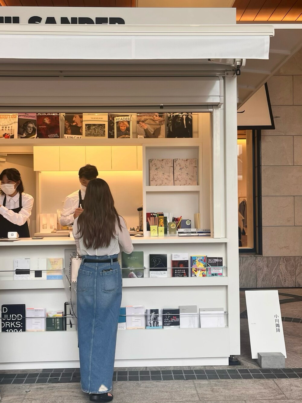 ブルー系のデニムスカートを着用したレディースの春コーディネートの3枚目の写真