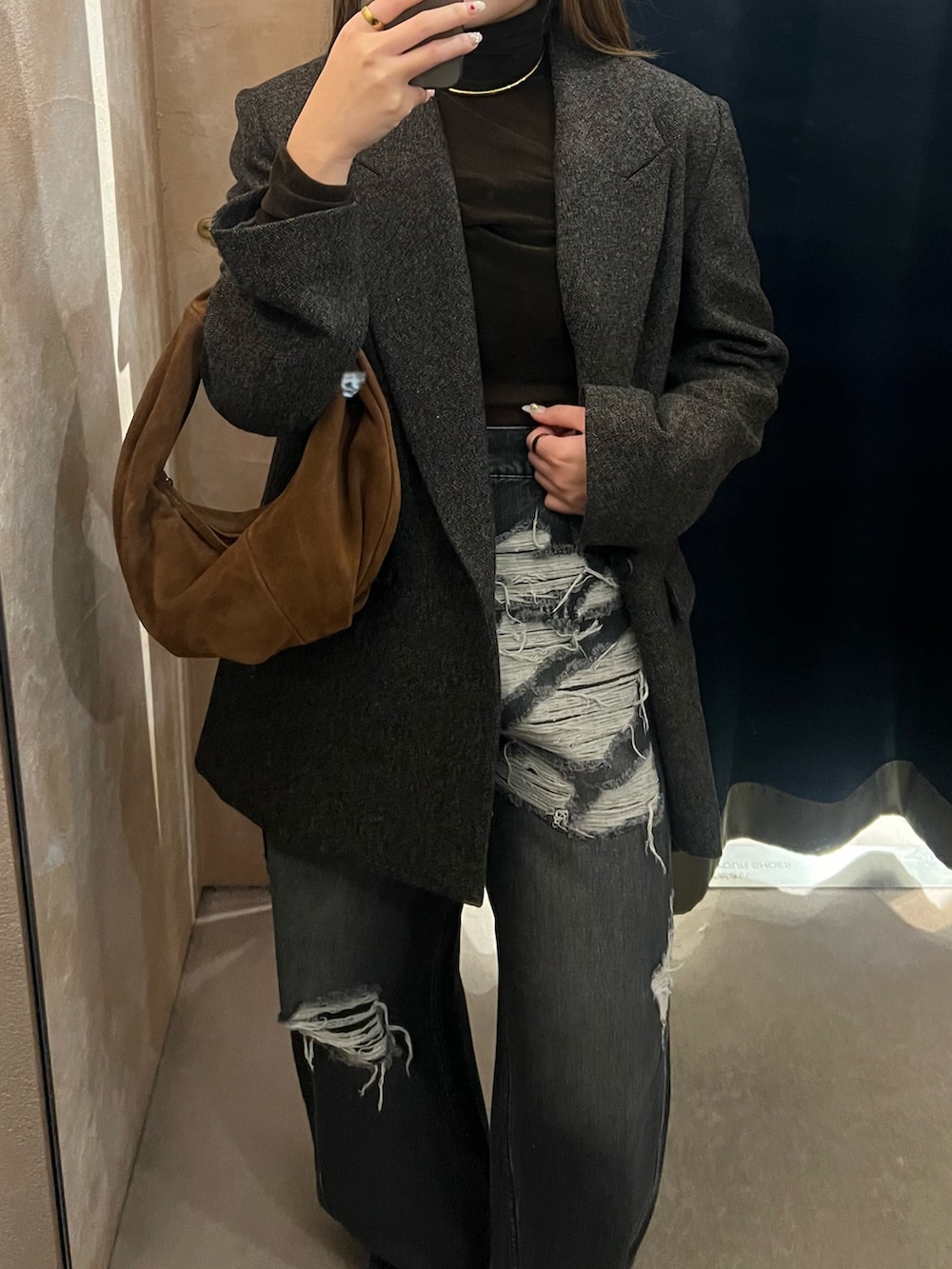 ブラック系のデニムパンツを着用したレディースの秋コーディネートの2枚目の写真