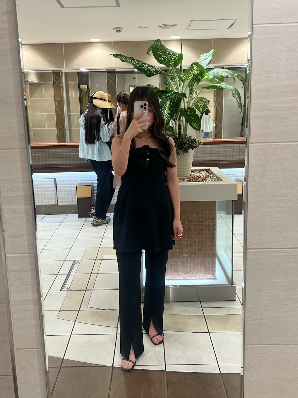 ブラック系のスラックスを着用したレディースの夏コーディネートの2枚目の写真
