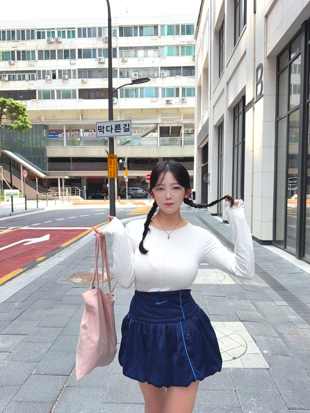 ホワイト系のTシャツ/カットソー、ブルー系のスカート、ピンク系のトートバッグを着用したレディースの秋コーディネートの5枚目の写真