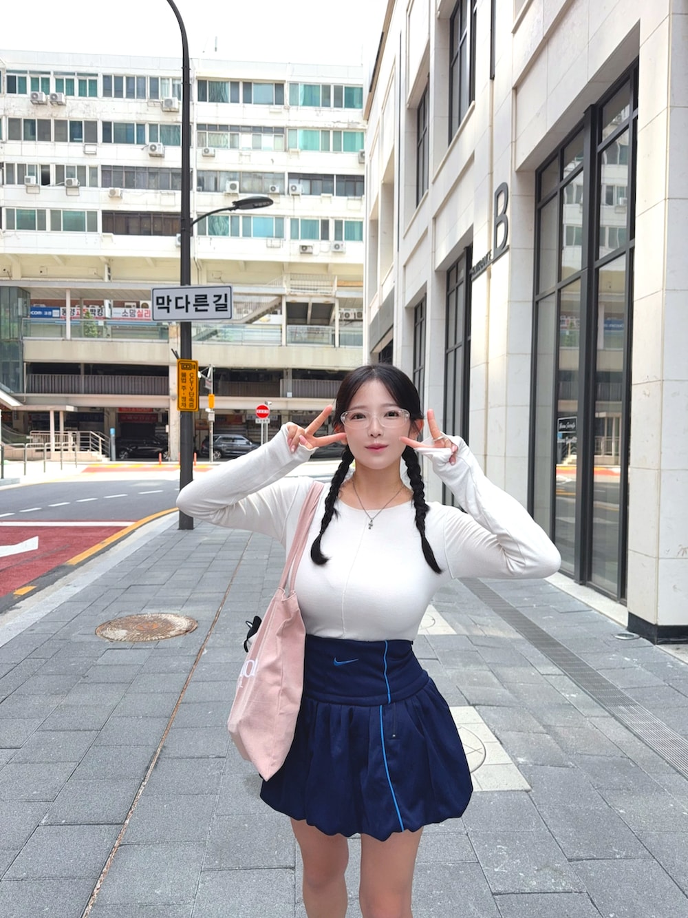 ホワイト系のTシャツ/カットソー、ブルー系のスカート、ピンク系のトートバッグを着用したレディースの秋コーディネートの3枚目の写真