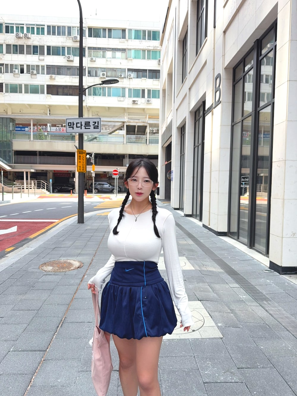 ホワイト系のTシャツ/カットソー、ブルー系のスカート、ピンク系のトートバッグを着用したレディースの秋コーディネートの2枚目の写真