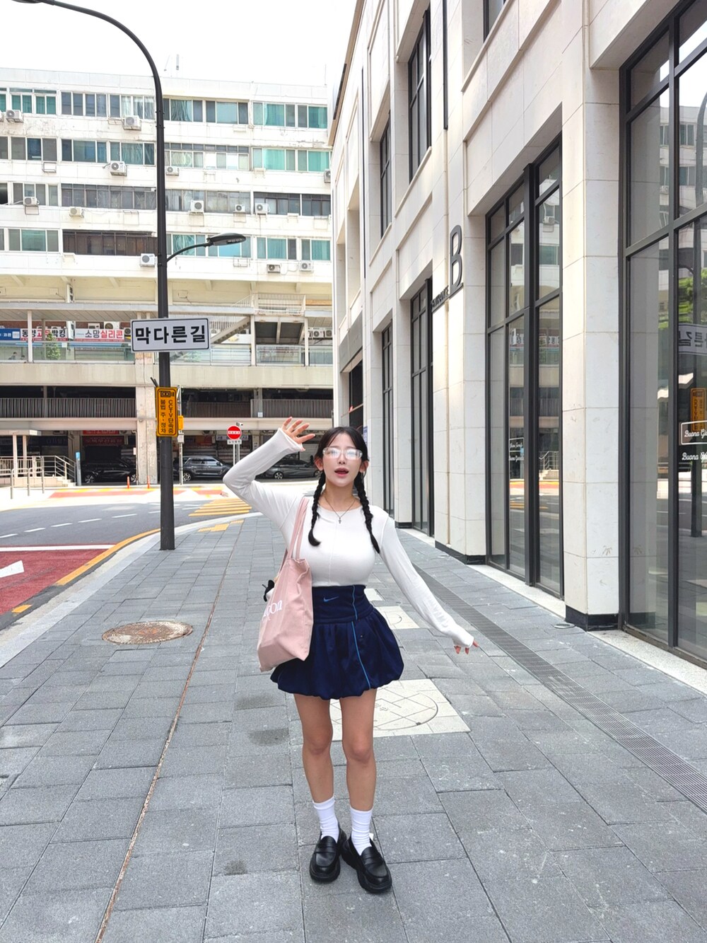 ホワイト系のTシャツ/カットソー、ブルー系のスカート、ピンク系のトートバッグを着用したレディースの秋コーディネートの4枚目の写真