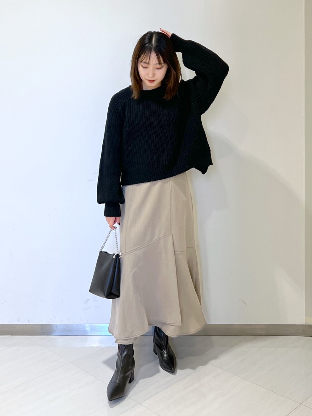 ブラック系のタンクトップ、ブラック系のニット/セーター、ブラウン系のワンピースを着用したレディースの秋コーディネートの4枚目の写真