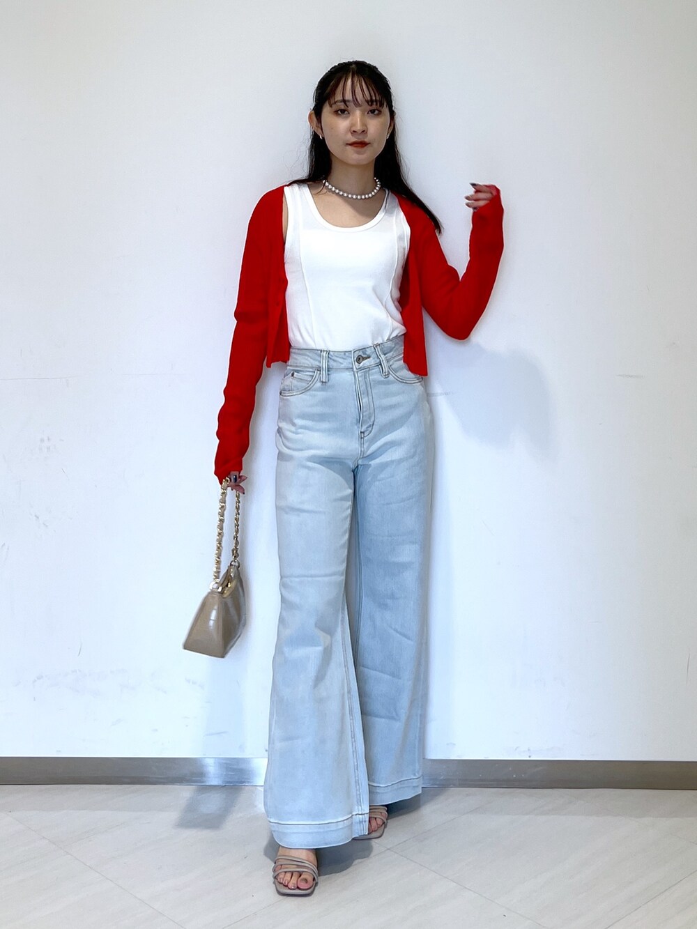 ブルー系のデニムパンツ、ベージュ系のトートバッグ、グレー系のサンダルを着用したレディースの夏コーディネートの3枚目の写真