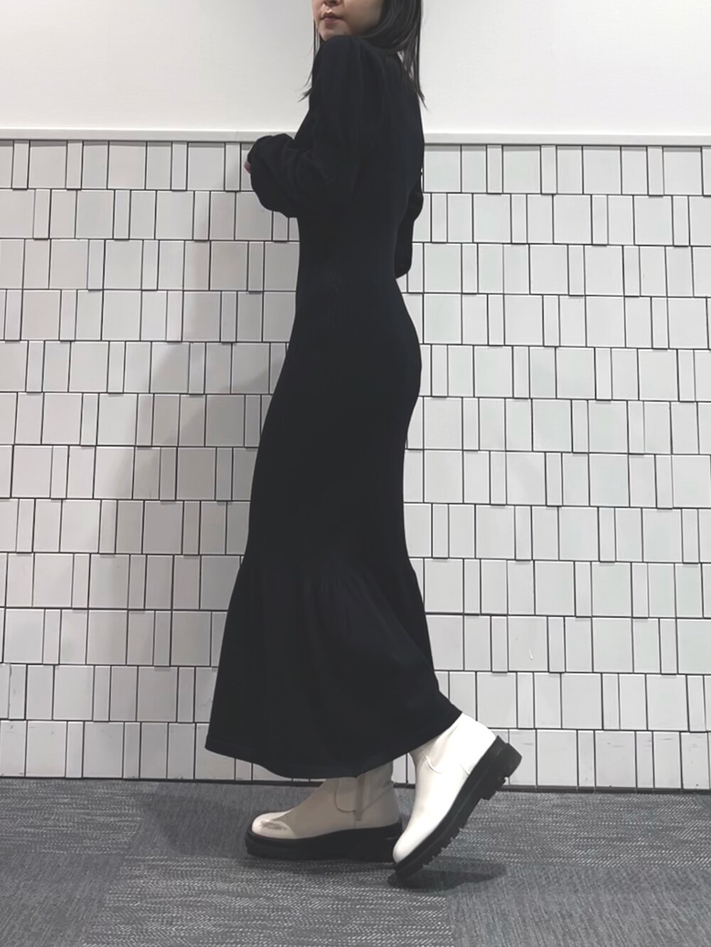 イエロー系のテーラードジャケット、ブラック系のワンピース、ホワイト系のブーツを着用したレディースの冬コーディネートの5枚目の写真