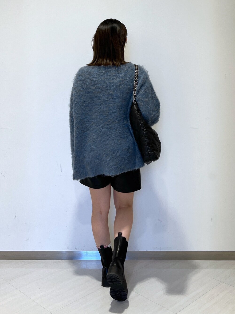 ブルー系のニット/セーター、ブラック系のトートバッグ、ブラック系のその他パンツを着用したレディースの冬コーディネートの5枚目の写真