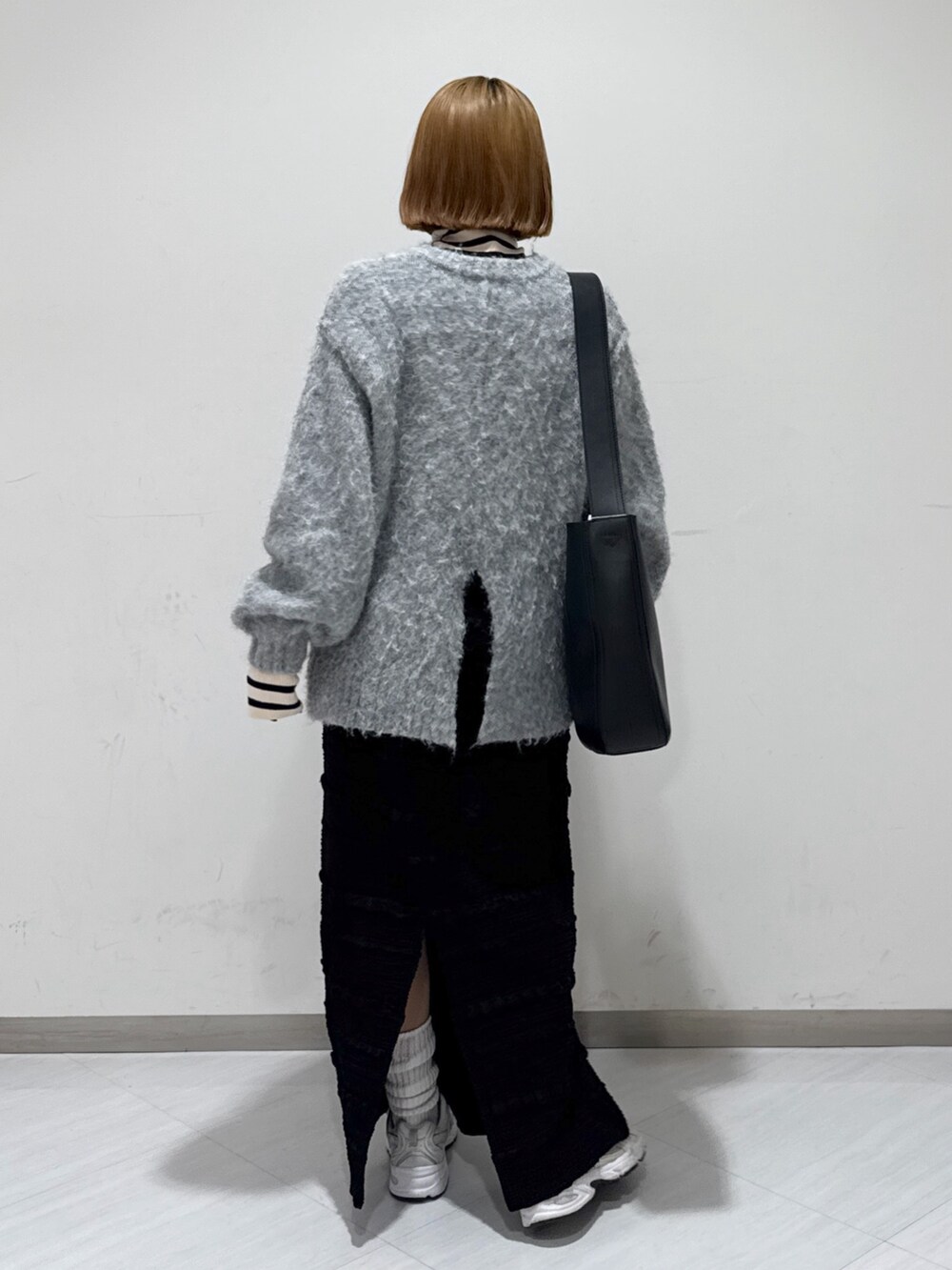 ホワイト系のダウンジャケット/コート、グレー系のニット/セーター、ベージュ系のニット/セーターを着用したレディースの冬コーディネートの5枚目の写真