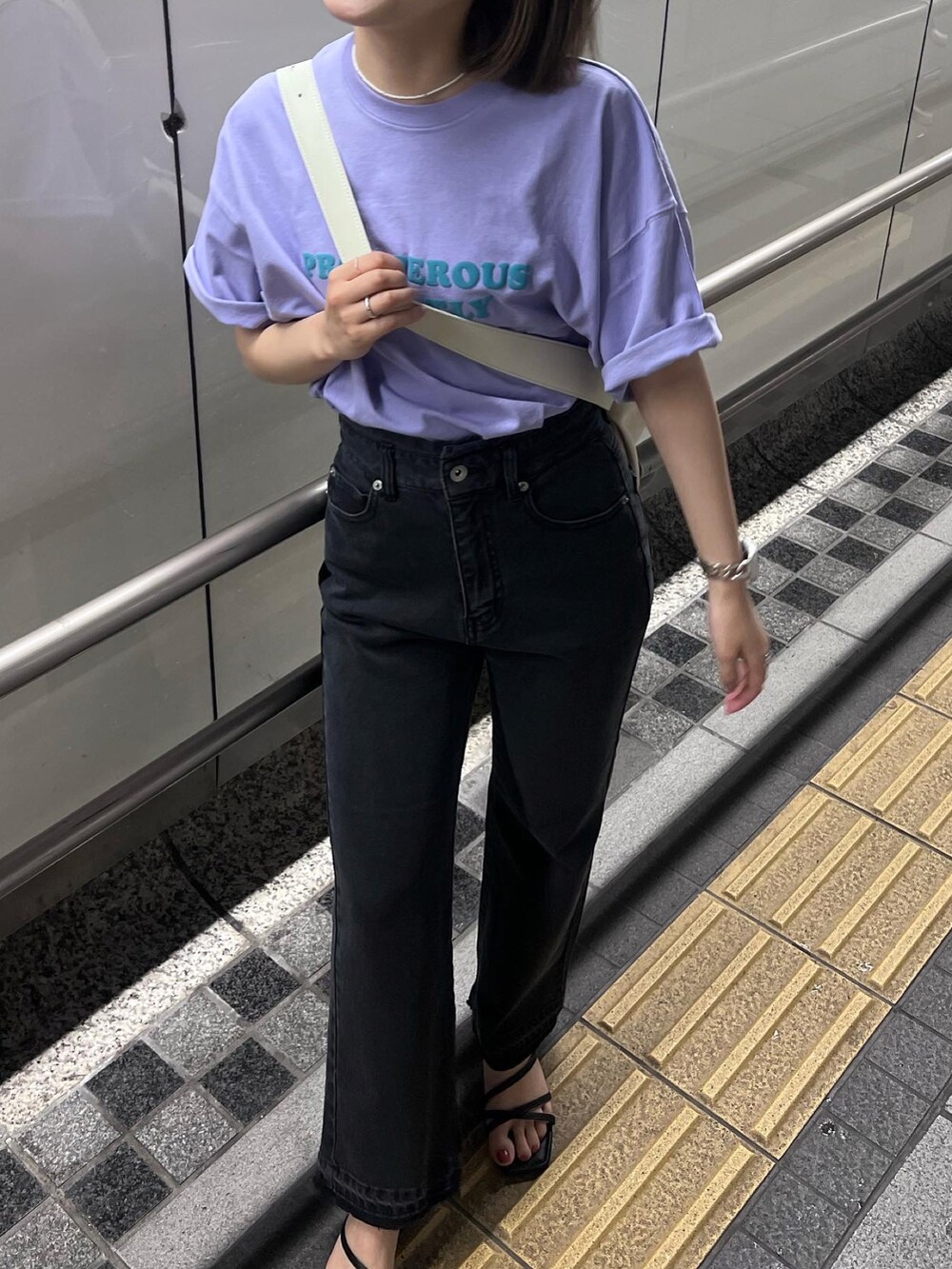 ブラック系のデニムパンツ、パープル系のTシャツ/カットソー、ホワイト系のボディバッグ/ウエストポーチを着用したレディースの春コーディネートの5枚目の写真