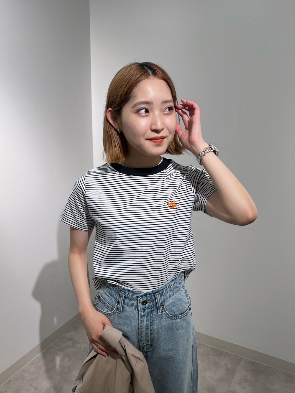 ベージュ系のテーラードジャケット、ブラック系のTシャツ/カットソー、ブルー系のデニムパンツを着用したレディースの夏コーディネートの6枚目の写真