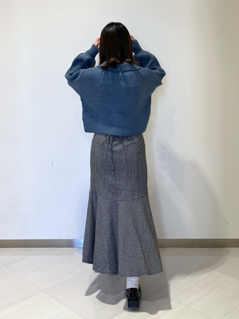 ブルー系のワンピース、ブラック系のスカート、ブラック系のバレエシューズを着用したレディースの冬コーディネートの5枚目の写真