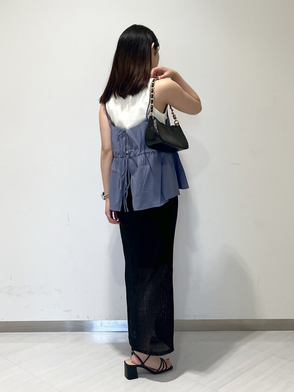 ホワイト系のタンクトップ、ブルー系のシャツ/ブラウス、ブラック系のトートバッグを着用したレディースの夏コーディネートの3枚目の写真