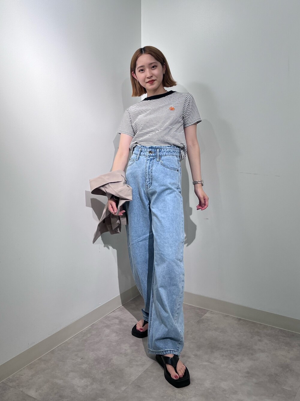 ベージュ系のテーラードジャケット、ブラック系のTシャツ/カットソー、ブルー系のデニムパンツを着用したレディースの夏コーディネートの4枚目の写真