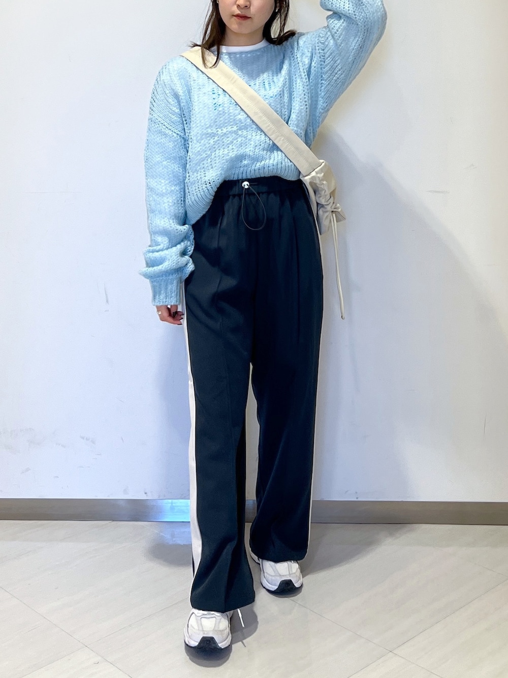 ホワイト系のショルダーバッグ、ブルー系のニット/セーター、ホワイト系のTシャツ/カットソーを着用したレディースの冬コーディネートの3枚目の写真