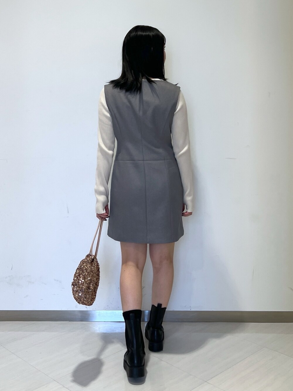 ホワイト系のニット/セーター、グレー系のワンピース、ピンク系のハンドバッグを着用したレディースの春コーディネートの5枚目の写真